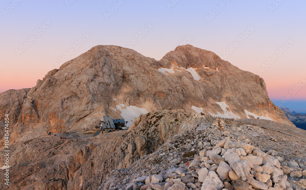 Triglav mountain hut with triglav mountain at the morning sun early morning golden hour blue hour, pastel
