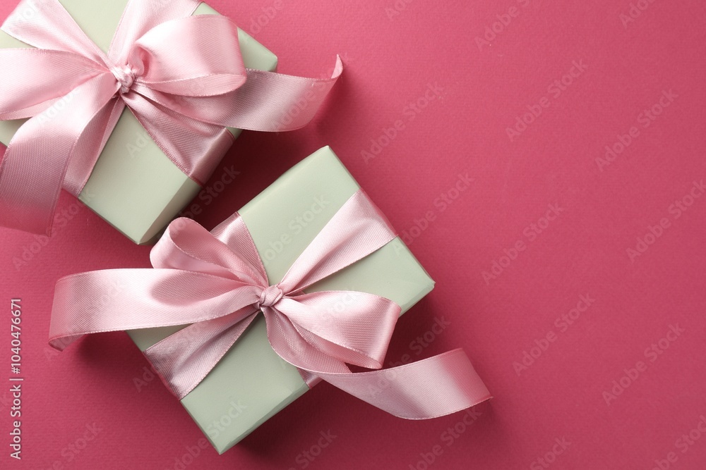 Beautiful gift boxes with bows on pink background, top view. Space for text Beautiful gift boxes with bows on pink background, top view. Space for text