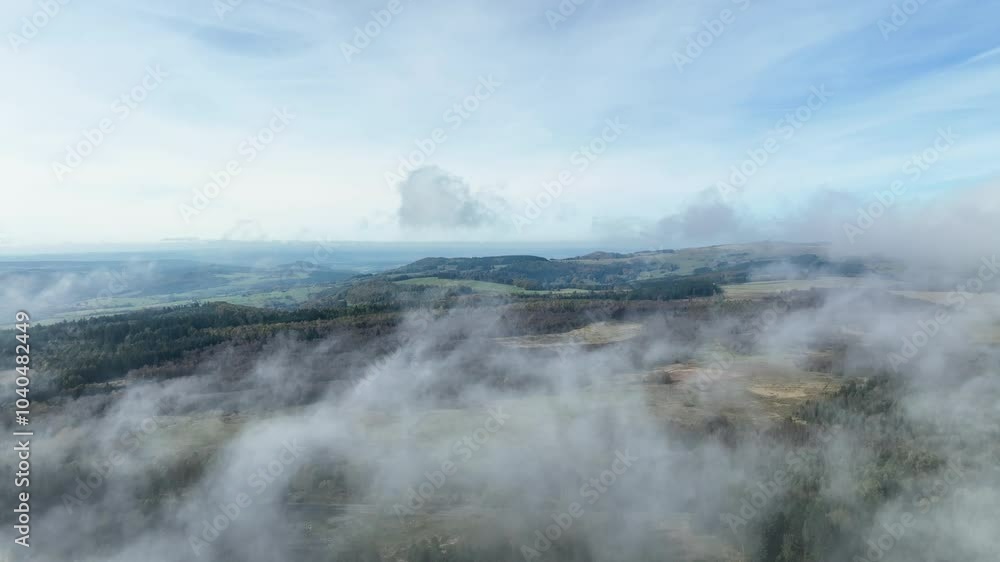 Fog and clouds over mountains and woodlands - drone point of view Fog and clouds over mountains and woodlands - drone point of view