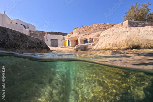 Underwater split photo of small cove and arch rock formations near  famous for colourful boat houses area of Karas, Kimolos island, Cyclades, Greece photo