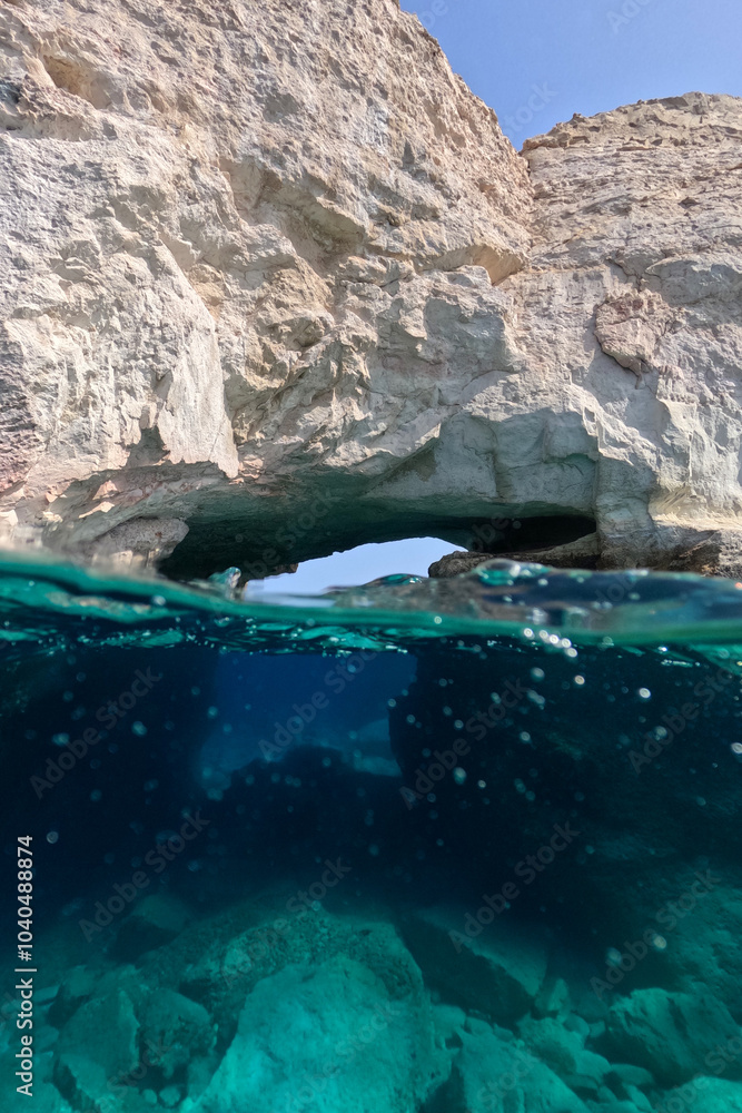 Underwater split photo of paradise exotic island rocky bay with crystal clear turquoise sea in Caribbean destination island