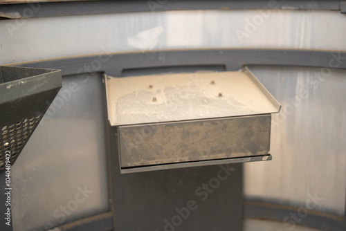 dusty metal mount with four visible bolts for securing a remote control. The surface shows signs of wear, indicating prolonged use or neglect photo