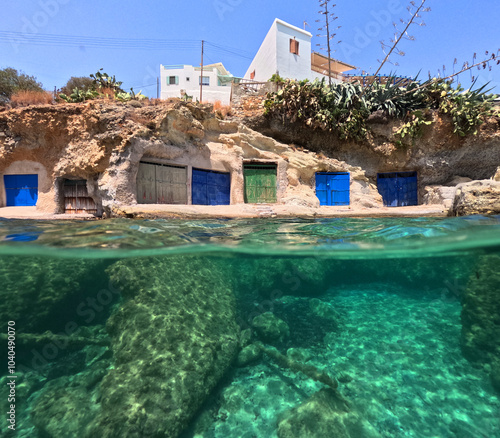 Underwater split photo of small cove of Rema famous for colourful boat houses called Sirmata, Kimolos island, Cyclades, Greece photo