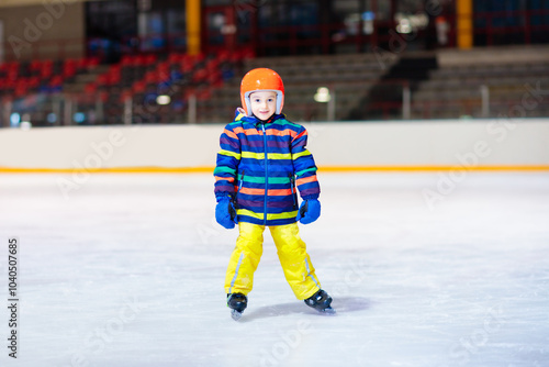 Child skating on indoor ice rink. Kids skate. photo