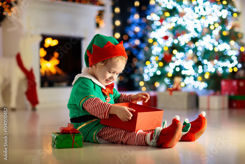 Kids at Christmas tree. Children open presents photo