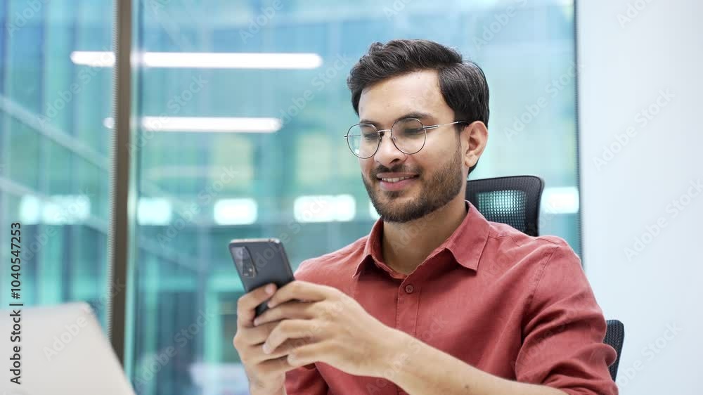 Smiling businessman is using, browsing smartphone while sitting at workplace in business office. Entrepreneur is chatting online, checking email, working in application or writing message. Close up Smiling businessman is using, browsing smartphone while sitting at workplace in business office. Entrepreneur is chatting online, checking email, working in application or writing message. Close up