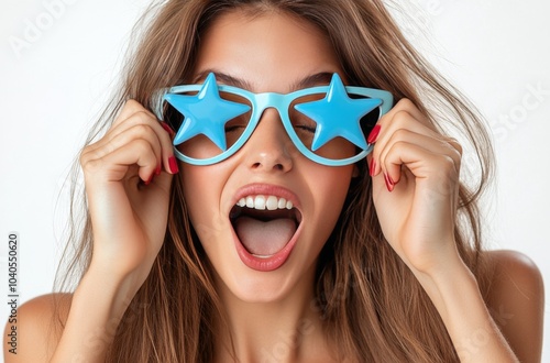 Cheerful woman wearing star shaped sunglasses and smiling against a bright bl...