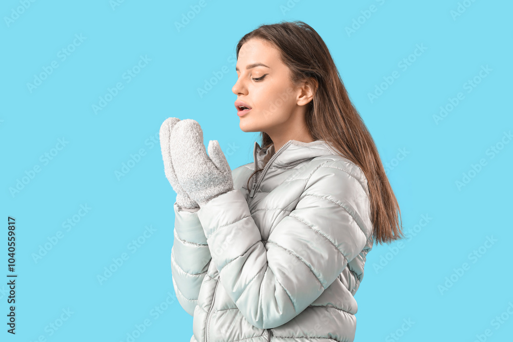 Young woman in winter clothes on blue background Young woman in winter clothes on blue background