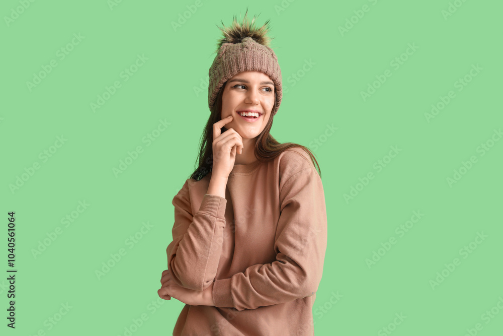 Young woman in winter clothes on green background Young woman in winter clothes on green background