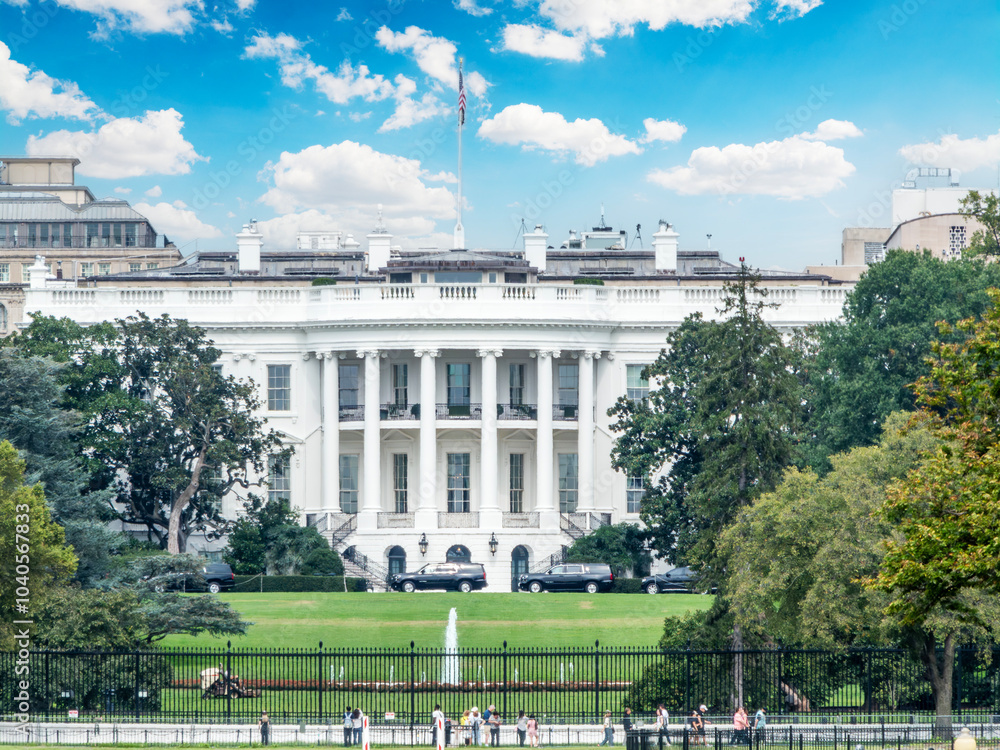 The White House under a blue sky with clouds