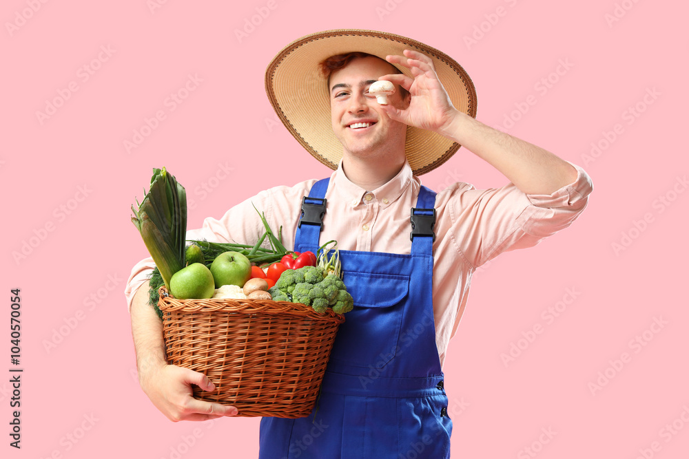 Male farmer with fresh vegetables on pink background Male farmer with fresh vegetables on pink background