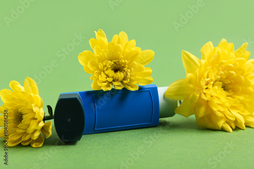 Modern inhaler and chrysanthemum flowers on green background photo