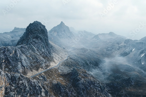 alpine highway winding through rugged peaks, subtle atmospheric haze