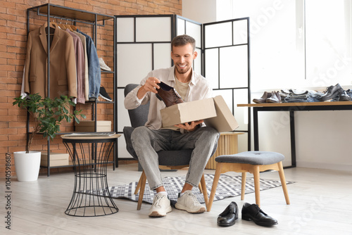 Young man with new shoes sitting in store