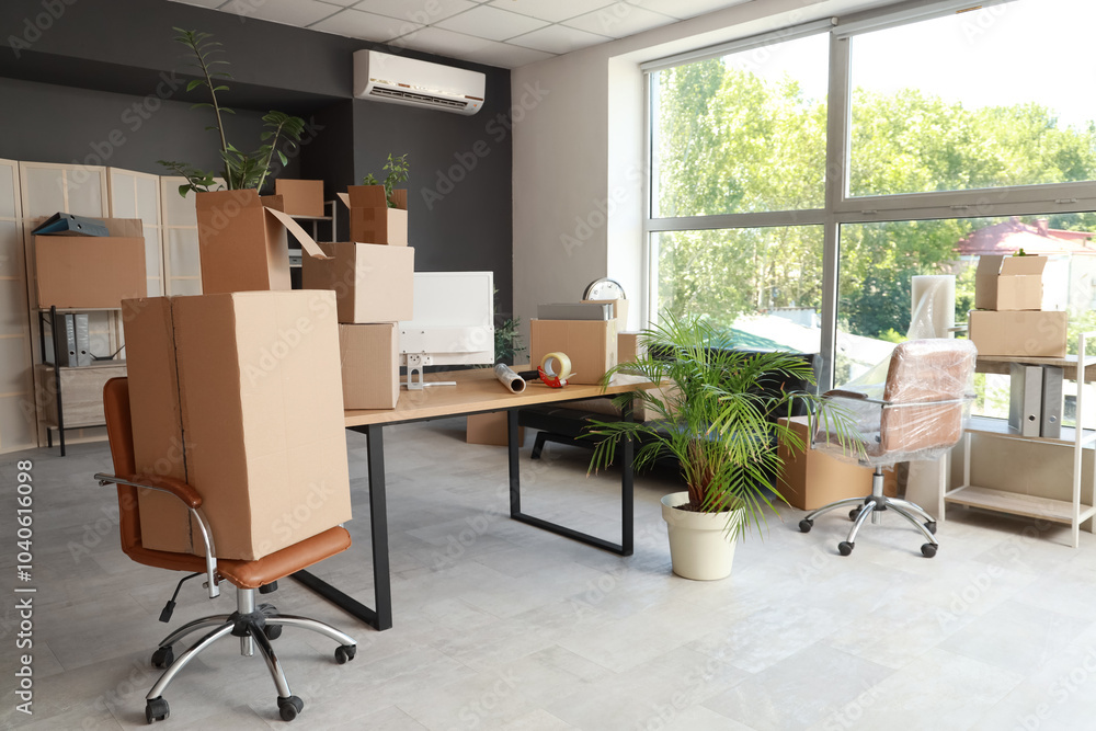 © Pixel-Shot - Workplace with chairs and cardboard boxes in office on moving day