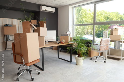 Foto Workplace with chairs and cardboard boxes in office on moving day