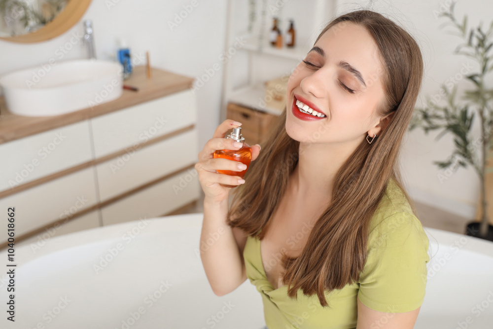 Young woman applying perfume in bathroom, closeup Young woman applying perfume in bathroom, closeup