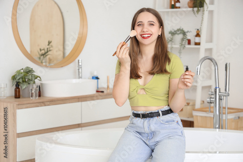 Young woman doing makeup in...