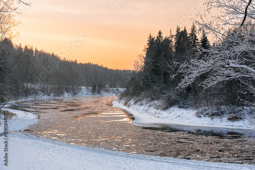 Gauja river on frosty and snowy winter evening during the sunset in Sigulda, Latvia photo