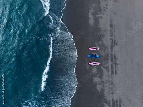 Photography Group of friends in wetsuit going to surf at beach, aerial top view