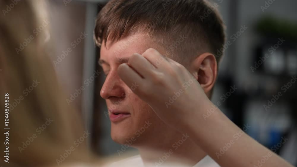 Female barber carefully cleaning male client eyebrows after haircut in stylish barbershop. Male client enjoying professional treatment for personal care and hygiene in beauty salon, slow motion. Female barber carefully cleaning male client eyebrows after haircut in stylish barbershop. Male client enjoying professional treatment for personal care and hygiene in beauty salon, slow motion.