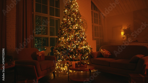 Decorated christmas tree is standing between two armchairs, illuminating a cozy living room with warm lights at night