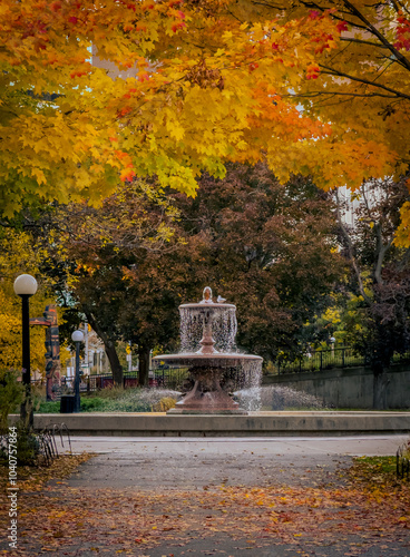 Obraz na plátně Fountain in Confederation Park, framed by vibrant autumn foliage with the colour