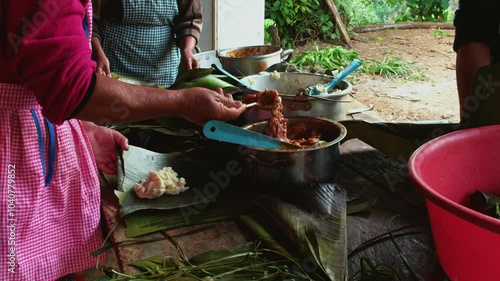 Adult women help prepare food for the family feast. The women make tamales.