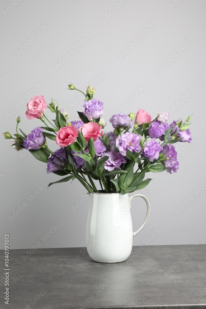 Vase with beautiful eustoma flowers on grey table Vase with beautiful eustoma flowers on grey table