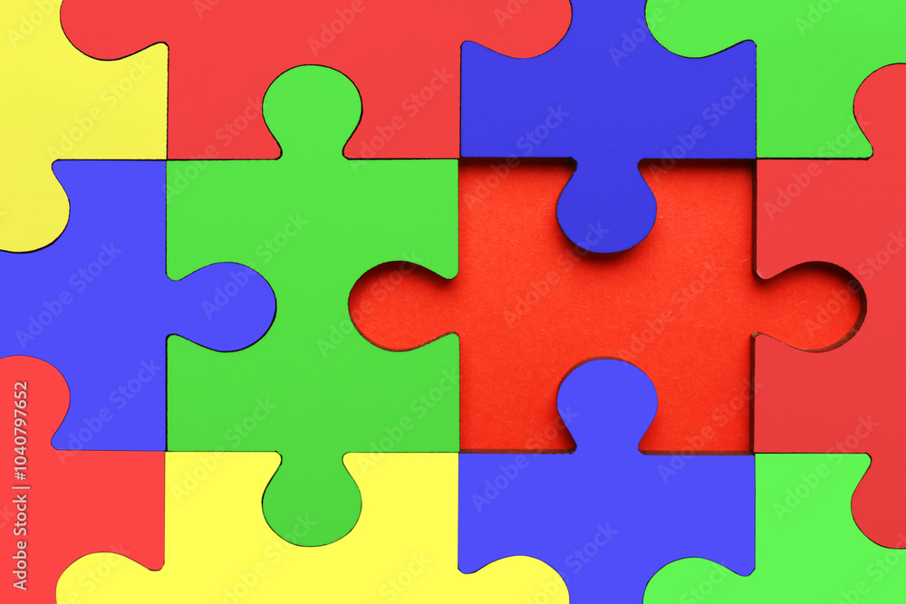 Many colorful puzzle pieces on red background, top view. Symbol of autism Many colorful puzzle pieces on red background, top view. Symbol of autism