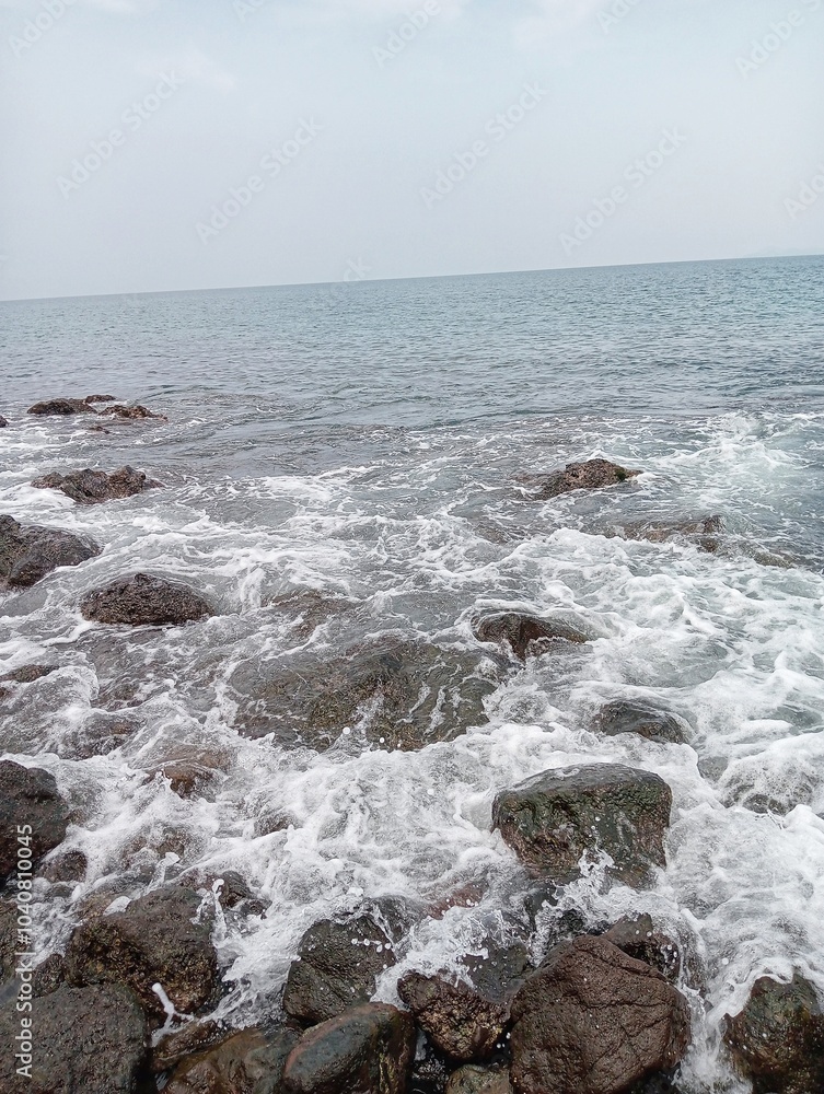 Fototapeta premium Waves crashing against the rocks on the shore