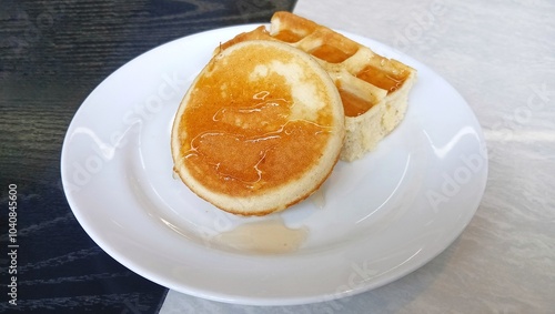 Waffles with honey sauce on a white plate