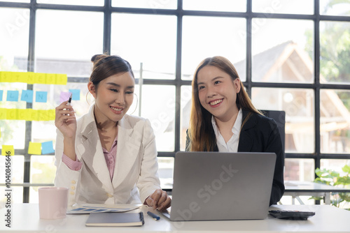 Two women talk, discuss, work on new project ideas. Analyze marketing plans and business investments to ensure success.