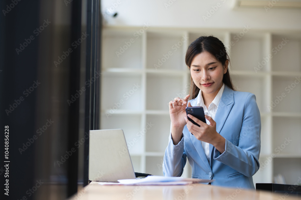 Beautiful Young Accountant Working in Modern Workspace with Laptop and Smartphone, Professional Businesswoman in Office Environment, Focused on Financial Tasks and Communication Beautiful Young Accountant Working in Modern Workspace with Laptop and Smartphone, Professional Businesswoman in Office Environment, Focused on Financial Tasks and Communication