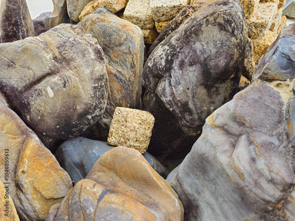 A unique square stone found among a group of large natural stones. A unique square stone found among a group of large natural stones.