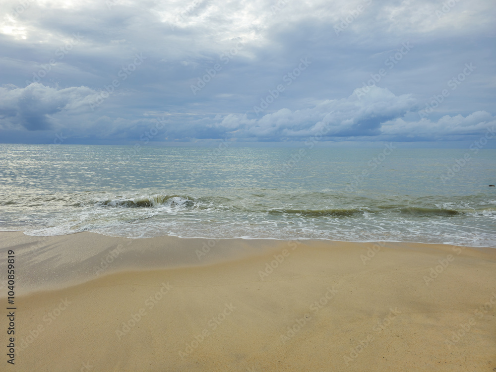 Fototapeta premium Sea view with the beach, waves, blue sky, and fluffy clouds.