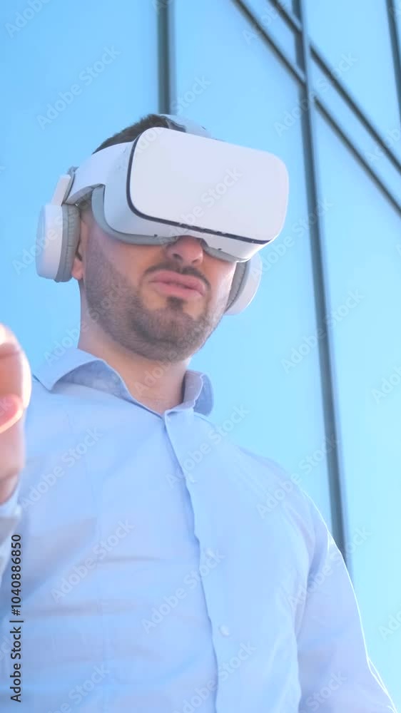 Office manager in 3D glasses on the background of a glass skyscraper. Vertical video Office manager in 3D glasses on the background of a glass skyscraper. Vertical video