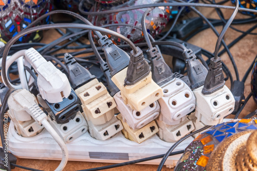 фотографія Old and damaged electric adapter power plug has many appliances are plugged outlet socket concept of risk danger overloaded current electrical