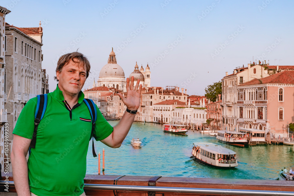 A tourist man person enjoys a picturesque view of the Grand Canal while exploring Venice, Italy
