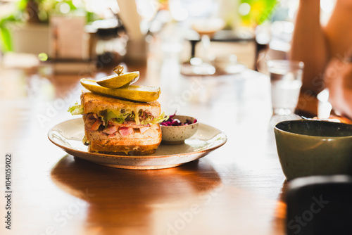 Cheese sandwich with pickles on a plate in cafe. photo