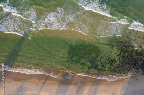 Aerial views of waves from the sea crashing against the beach in Fingal Head, New South Wales, Australia photo