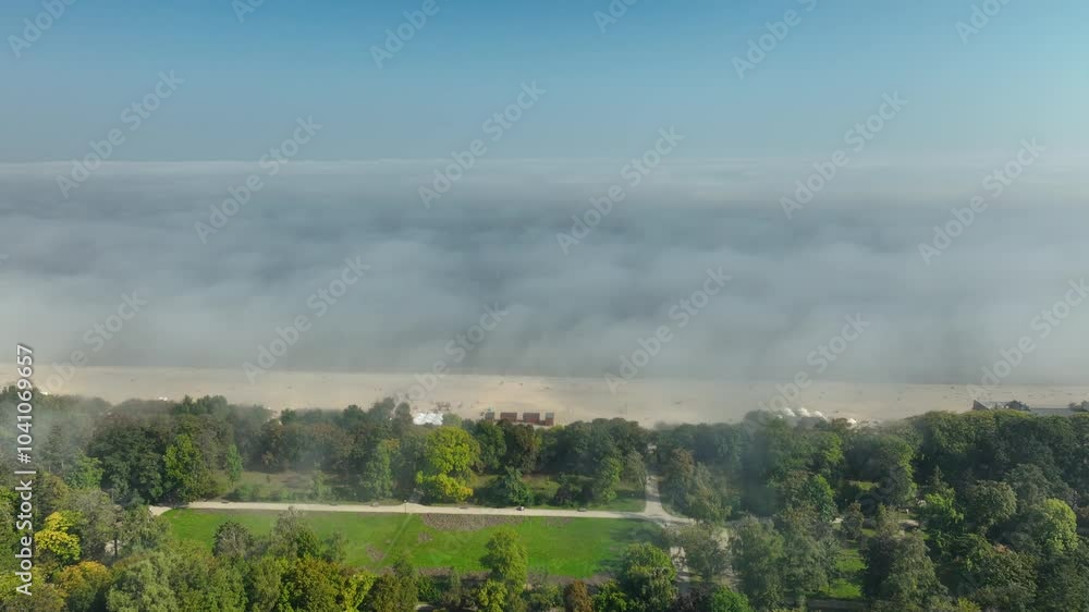 A foggy beachside view of Sopot taken from above, with green parks and sandy shores blending into the misty horizon A foggy beachside view of Sopot taken from above, with green parks and sandy shores blending into the misty horizon