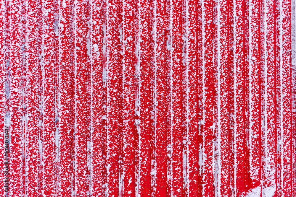 Red textured surface, traditional striped winter pattern. Snow on metal, close up Red textured surface, traditional striped winter pattern. Snow on metal, close up