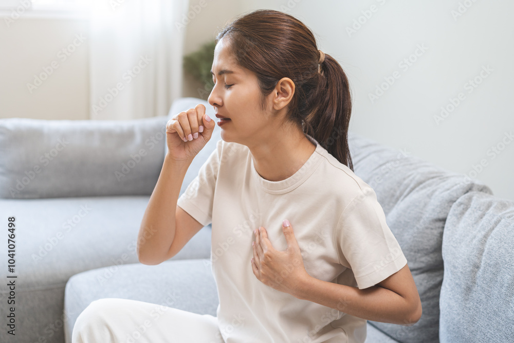 Health care of coronavirus concept, unhealthy and sickness, asian young woman, girl unwell and coughing, hand touch her chest, female sore throat suffering with symptom cough feeling bad at home. Health care of coronavirus concept, unhealthy and sickness, asian young woman, girl unwell and coughing, hand touch her chest, female sore throat suffering with symptom cough feeling bad at home.