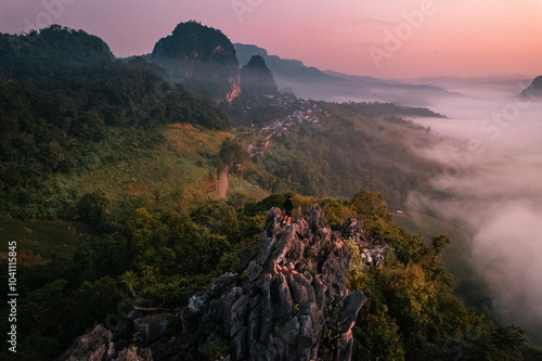 Aerial view of Morning fog and mountains with a rural village and sunrise from above photo