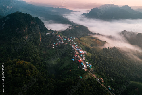 Aerial view of Morning fog and mountains with a rural village and sunrise from above photo