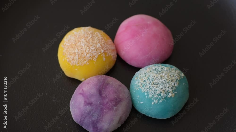 Delicious colorful asian mochi sweets with rice dough shell and fruit filling on dark concrete background Delicious colorful asian mochi sweets with rice dough shell and fruit filling on dark concrete background