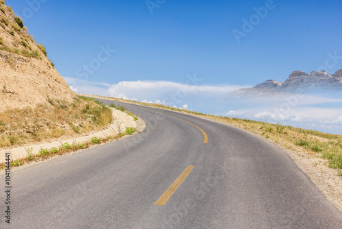 Asphalt road and mountain nature landscape under blue sky. Road trip.