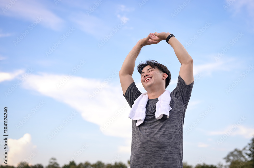 Happy young asian man breathing fresh air and relaxing after workout in nature Happy young asian man breathing fresh air and relaxing after workout in nature