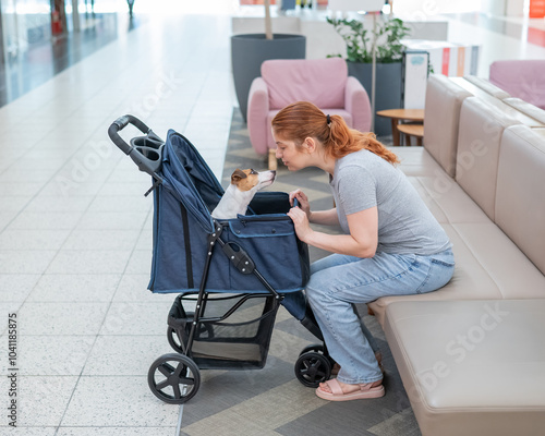 Caucasian woman petting her Jack Russell terrier dog. Shopping with a pet in the mall. photo